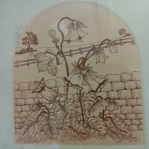 Op de afbeelding: Een bruine en witte print van een bloemenontwerp met de tekst "of Nature's Bells 188/250 Aleman '80".