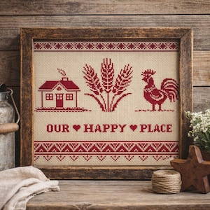 May include: Framed cross-stitch artwork featuring a red house, wheat stalks, and a rooster on a beige background. The text "OUR HAPPY PLACE" is stitched below the images. The artwork is in a rustic wooden frame.