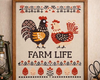 May include: Framed cross-stitch artwork featuring a rooster and hen with the text "FARM LIFE." The rooster is black with orange and brown accents, and the hen is red and white. The artwork has a decorative border with floral and egg motifs.
