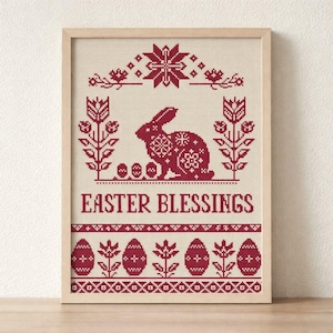 May include: Framed cross-stitch artwork featuring a red Easter bunny, eggs, and floral elements on a beige background. The words "EASTER BLESSINGS" are displayed below the bunny. The artwork is in a light wooden frame.