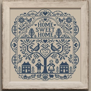 Puede incluir: Obra de arte en punto de cruz enmarcada con un fondo crema y un diseño azul. El diseño presenta las palabras "HOME SWEET HOME" y un árbol con pájaros, casas y figuras. El marco es de color beige claro.
