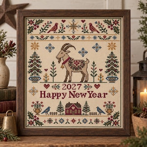 Puede incluir: Un bordado en punto de cruz enmarcado que presenta una cabra central con una manta estampada y una campana. El diseño incluye pinos, pájaros, copos de nieve y una casa, con el texto 2027 Happy New Year bordado en rojo sobre tela color crema.