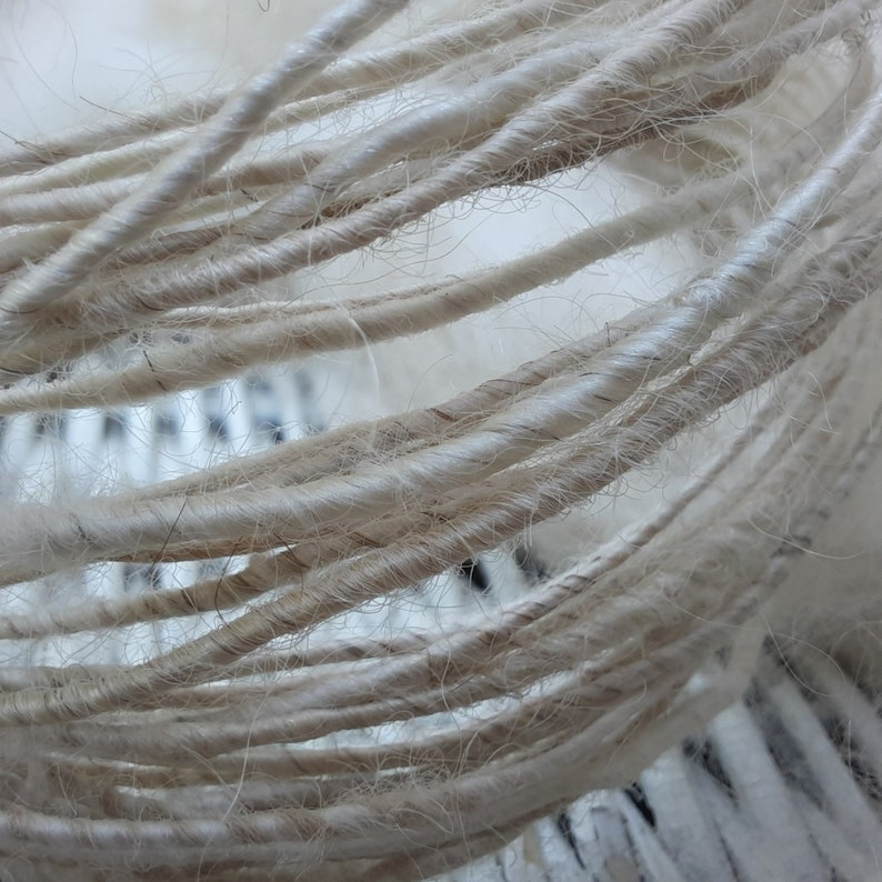 May include: Close-up of a bundle of natural white twine, showing the texture and fibers of the material.