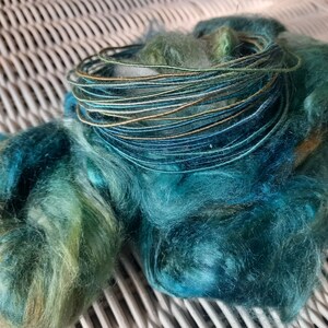 100% Silk fiber wire in teal, blue, green, and gold.  Core spun craft wire