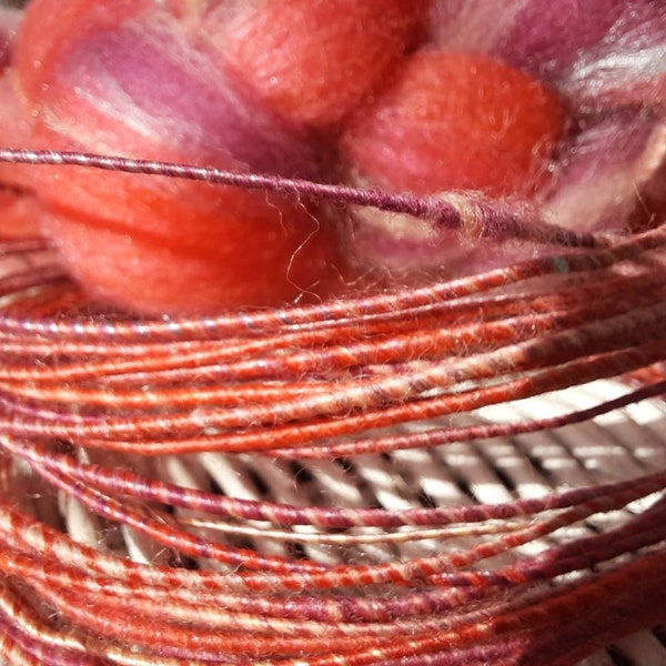 Fil de fibre de laine dans le corail lumineux, rose, et pourpre.