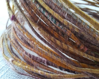 Wool fiber wire.  Pale purlpe/mauve, golden orange wool with silk and recycled silk saris