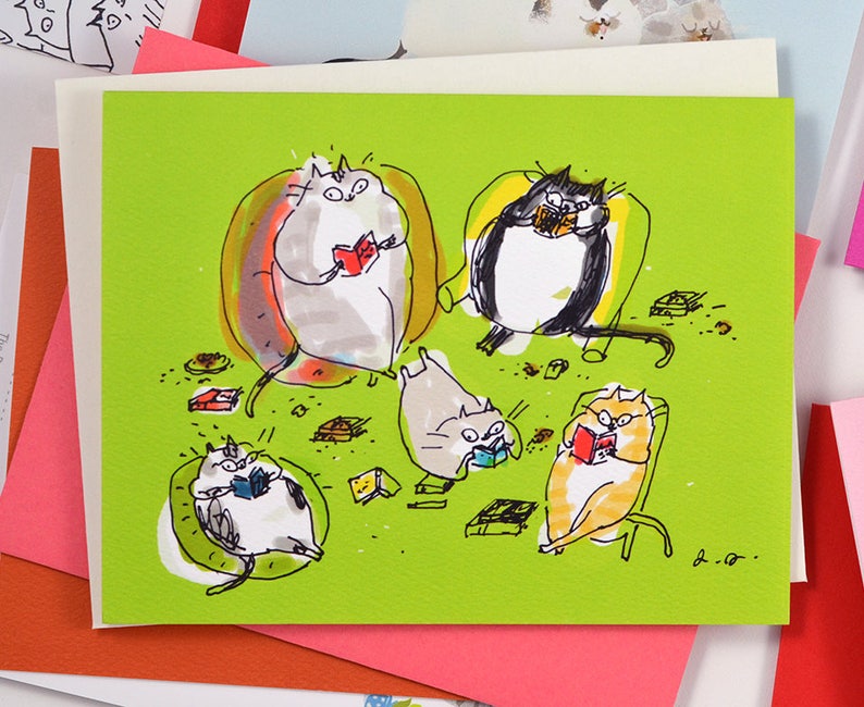 May include: A green card featuring a drawing of five cats engrossed in reading books. The cats are seated in chairs and on the floor, surrounded by books and other objects. The card is signed "B.A.R."