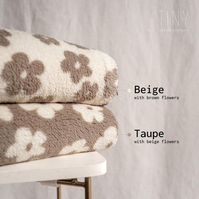 Puede incluir: Dos mantas de felpa con un patr&oacute;n floral. La manta superior es beige con flores marrones. La manta inferior es topo con flores beige. El texto "TINY SEWING COMPANY" est&aacute; en la esquina superior derecha de la imagen.