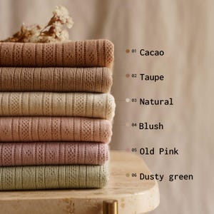 May include: A stack of six knitted fabrics in various colors: Cacao, Taupe, Natural, Blush, Old Pink, and Dusty Green. Each fabric has a delicate, openwork design. The colors are labeled with corresponding numbers.