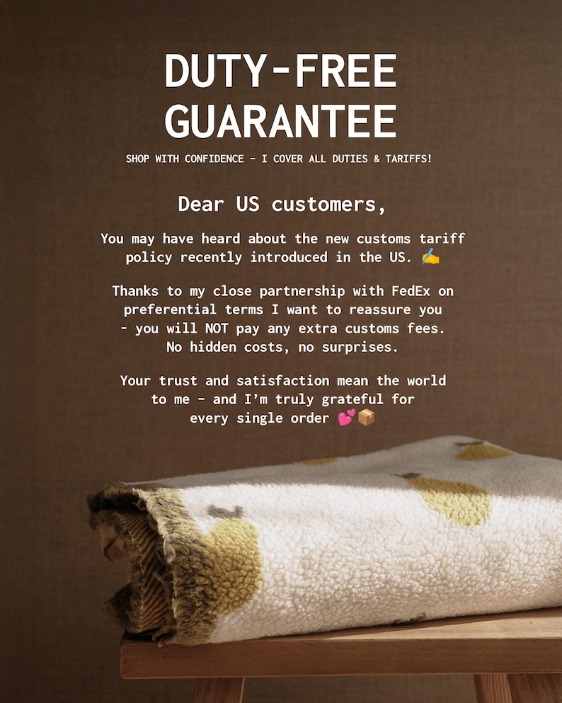 May include: A folded white and yellow patterned blanket rests on a wooden surface. The image includes text that reads "DUTY-FREE GUARANTEE" and a message to US customers about customs fees.