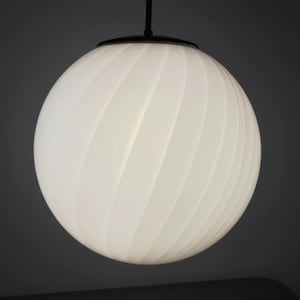 May include: A white, spherical pendant light with a ribbed design. The light fixture is suspended from a black cord and a circular black canopy. The overall design is modern and minimalist, suitable for various interior styles.