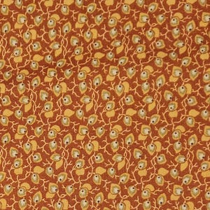 May include: Close-up of a fabric with a repeating pattern of small leaves and vines. The leaves are a mix of yellow and white, set against a reddish-brown background. The design is dense and detailed.