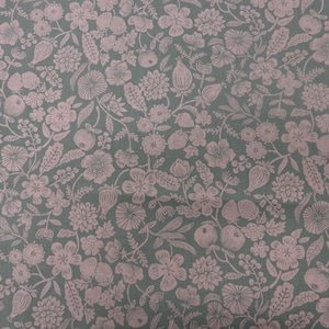 May include: A fabric with a repeating floral pattern in shades of dusty rose and muted green. The design features various flowers, fruits, and foliage, creating a vintage or botanical aesthetic. The overall look is soft and detailed.