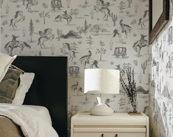 Può includere: Una camera da letto con un comodino bianco e una lampada. La parete è rivestita di una carta da parati con un motivo in bianco e nero di cavalli e cowboy. Il letto ha un piumino bianco e una coperta marrone.