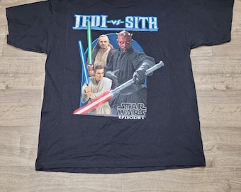 May include: Black Star Wars Episode I t-shirt featuring the text "Jedi vs Sith" above a graphic of three characters with lightsabers. The graphic includes the text "Star Wars Episode I".