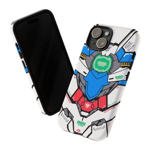 May include: A white phone case featuring a detailed graphic design with blue, red, and green accents. The design resembles a robot or mecha, with intricate paneling and geometric shapes. A black phone is next to the case.