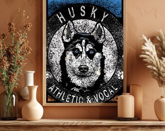 May include: A framed print depicting a Husky dog with blue eyes, in black and white, set against a blue backdrop. The text reads "HUSKY ATHLETIC & VOCAL". The print is displayed on a wooden table, with decorative vases and dried plants.