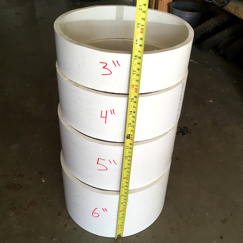 May include: A stack of four white plastic rings with measurements marked in inches. The rings are 3 inches, 4 inches, 5 inches, and 6 inches in diameter.