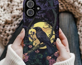 May include: A black phone case with a dark floral design and a raven perched on a branch under a yellow moon.