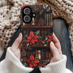 May include: A phone case featuring a festive design with a bookshelf motif. The case is adorned with red poinsettias, holly, pinecones, and berries. The background is a dark, rich brown, creating a cozy, holiday-themed aesthetic.