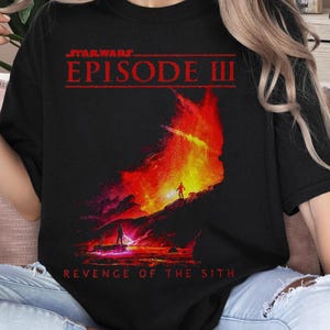 May include: Black t-shirt featuring a red and orange graphic of a fiery scene from Star Wars Episode III: Revenge of the Sith. The text "STAR WARS EPISODE III REVENGE OF THE SITH" is printed on the shirt.
