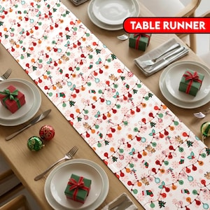 May include: A white Christmas table runner with a repeating pattern of colourful string lights, snowflakes, and festive icons. The rectangular runner features the text "TABLE RUNNER" in a red banner.
