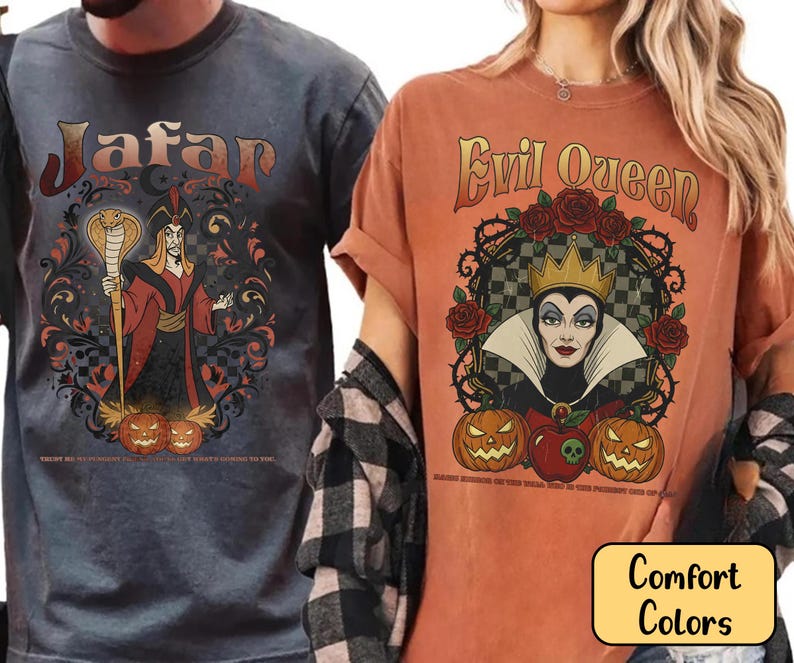 May include: Two t-shirts with graphic designs. One is a dark grey shirt with the word "Jafar" and a cartoon image of Jafar. The other is an orange shirt with the words "Evil Queen" and a cartoon image of the Evil Queen. Both shirts have pumpkins.