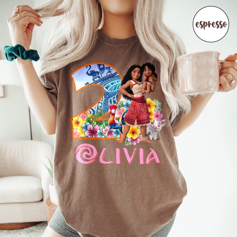 Peut inclure: T-shirt marron avec un num&eacute;ro deux rose, un graphique Moana et Maui, et le nom Olivia en rose.