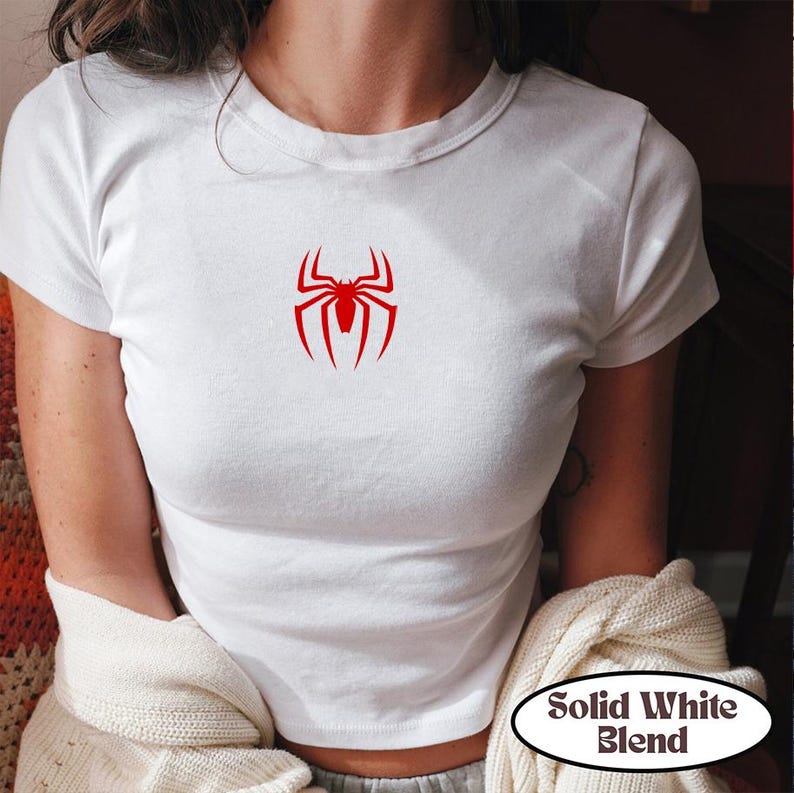 May include: White t-shirt with a red spider graphic. The shirt has short sleeves and a crew neck. The text "Solid White Blend" is in a white oval on the bottom right.