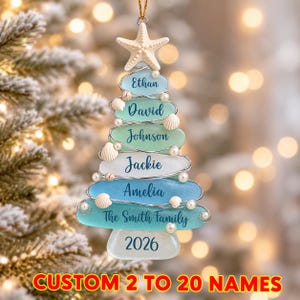 May include: A Christmas tree-shaped ornament made of stacked sea glass pieces in shades of blue, green, and white. The ornament features a white starfish topper, small white seashells, and pearls. It is personalised with the names Ethan, David, Johnson, Jackie, Amelia, The Smith Family, and the year 2026.
