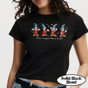 May include: Black t-shirt featuring four cartoon characters dressed as wizards. Each character is wearing a blue wizard hat and red robes. The text "Some imagination, huh?" is below the characters. The shirt has a "Solid Black Blend" label.