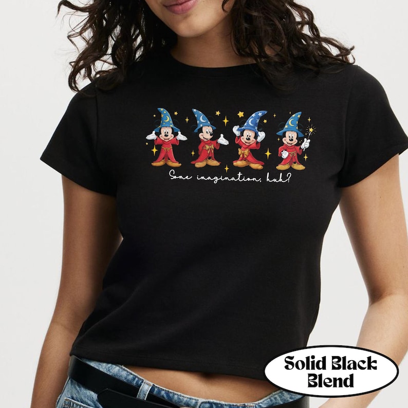 May include: Black t-shirt featuring four cartoon characters dressed as wizards. Each character is wearing a blue wizard hat and red robes. The text "Some imagination, huh?" is below the characters. The shirt has a "Solid Black Blend" label.