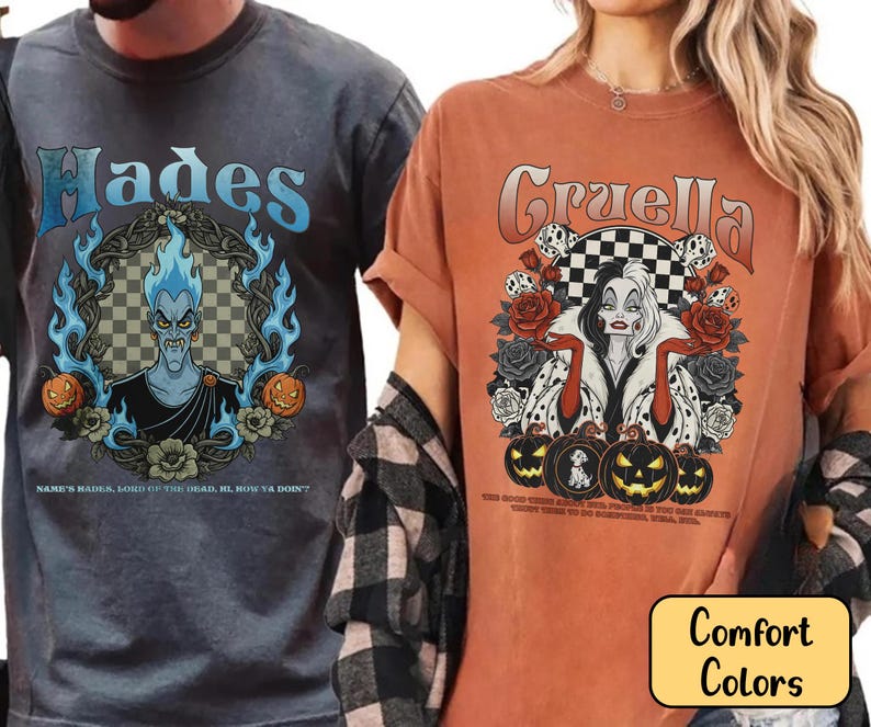 May include: Two t-shirts, one grey and one orange, with graphic designs. The grey shirt features "Hades" with a character illustration and text. The orange shirt displays "Cruella" with a character illustration, roses, and pumpkins.