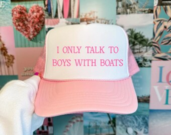 May include: Pink and white trucker hat with the text "I only talk to boys with boats" in pink lettering.