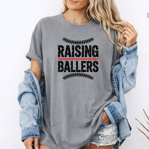 For moms who live at the ballpark, this Raising Ballers Comfort Colors® shirt is the perfect match. The relaxed fit and soft garment dyed fabric provide all day comfort while the sporty design celebrates the pride of raising young athletes. Perfect for baseball games, softball events, and casual outfits.