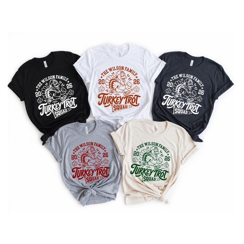 a collection of five T-shirts, each with a unique design and color, arranged in a row.
