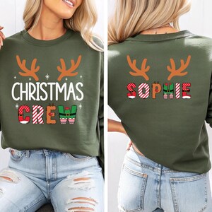 cute christmas crew sweatshirt with reindeer antlers and personalized sleeve name option, matching holiday family sweater for kids and adults, custom christmas shirt for winter celebrations, cozy xmas crew top with festive lettering, personalized holiday gift sweatshirt, christmas pajamas top for family photos, fun reindeer themed christmas sweater, holiday party outfit idea, custom name christmas crew shirt, adorable winter sweatshirt for holiday season