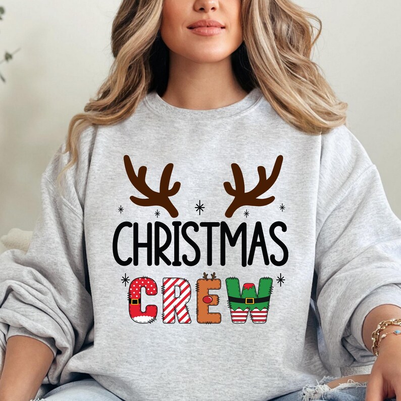 cute christmas crew sweatshirt with reindeer antlers and personalized sleeve name option, matching holiday family sweater for kids and adults, custom christmas shirt for winter celebrations, cozy xmas crew top with festive lettering, personalized holiday gift sweatshirt, christmas pajamas top for family photos, fun reindeer themed christmas sweater, holiday party outfit idea, custom name christmas crew shirt, adorable winter sweatshirt for holiday season