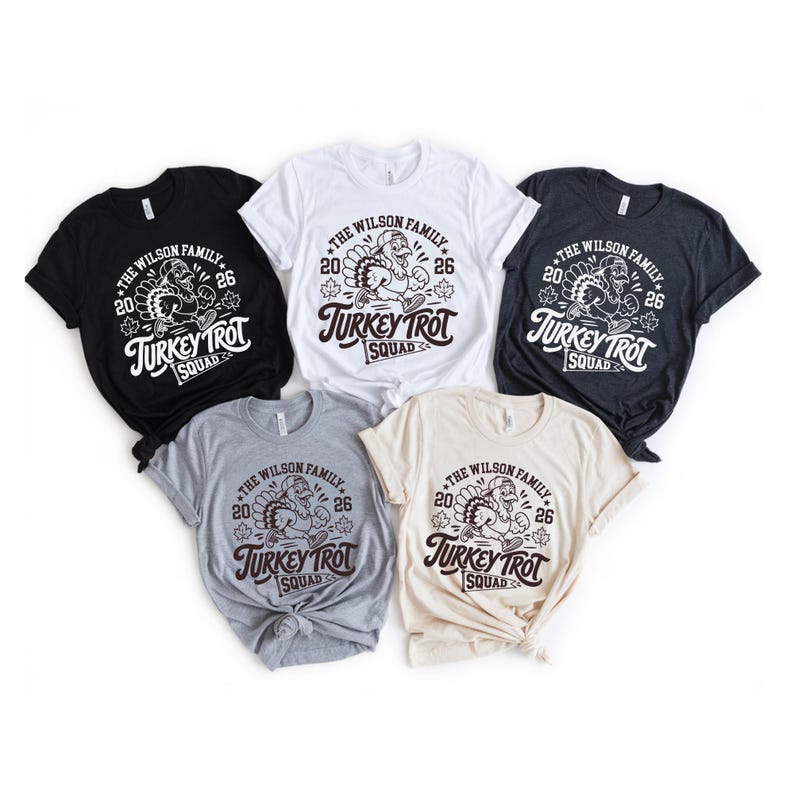 a collection of five T-shirts, each with a unique design and color, arranged in a row.