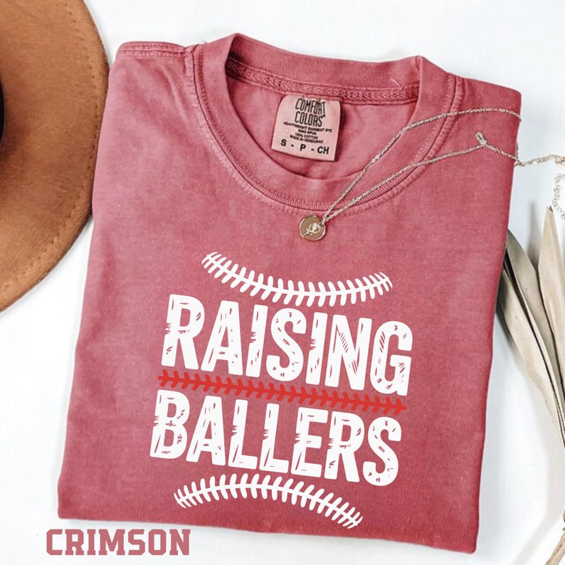 Show your sports mom pride with this Raising Ballers Comfort Colors® t-shirt. Designed with a classic baseball inspired graphic, this relaxed fit tee is perfect for baseball games, softball tournaments, and weekend practices. The soft garment dyed fabric gives it a vintage look and feel that sports moms love. A perfect gift for baseball and softball moms.