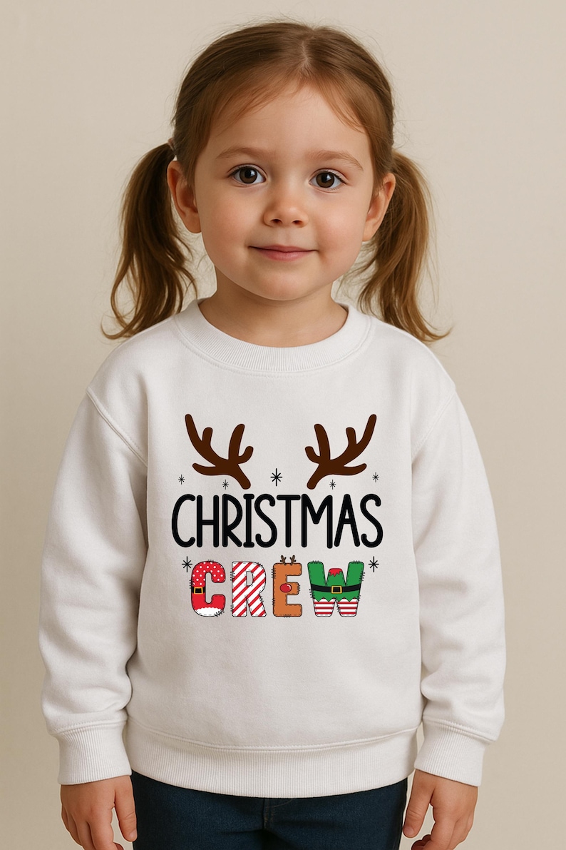 cute christmas crew sweatshirt with reindeer antlers and personalized sleeve name option, matching holiday family sweater for kids and adults, custom christmas shirt for winter celebrations, cozy xmas crew top with festive lettering, personalized holiday gift sweatshirt, christmas pajamas top for family photos, fun reindeer themed christmas sweater, holiday party outfit idea, custom name christmas crew shirt, adorable winter sweatshirt for holiday season