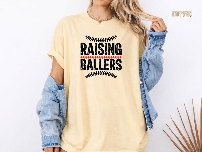 Raising Ballers perfectly describes the life of a dedicated sports mom. This Comfort Colors® baseball mom shirt features a classic sporty design that looks great at the ballpark or anywhere. The soft garment dyed cotton gives a relaxed vintage feel that makes it a favorite for game days and everyday wear.