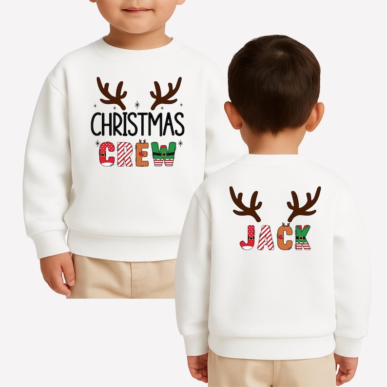 cute christmas crew sweatshirt with reindeer antlers and personalized sleeve name option, matching holiday family sweater for kids and adults, custom christmas shirt for winter celebrations, cozy xmas crew top with festive lettering, personalized holiday gift sweatshirt, christmas pajamas top for family photos, fun reindeer themed christmas sweater, holiday party outfit idea, custom name christmas crew shirt, adorable winter sweatshirt for holiday season