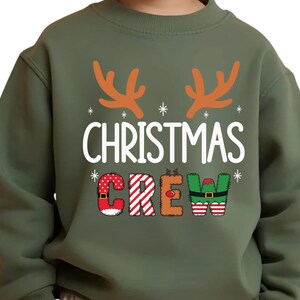 cute christmas crew sweatshirt with reindeer antlers and personalized sleeve name option, matching holiday family sweater for kids and adults, custom christmas shirt for winter celebrations, cozy xmas crew top with festive lettering, personalized holiday gift sweatshirt, christmas pajamas top for family photos, fun reindeer themed christmas sweater, holiday party outfit idea, custom name christmas crew shirt, adorable winter sweatshirt for holiday season