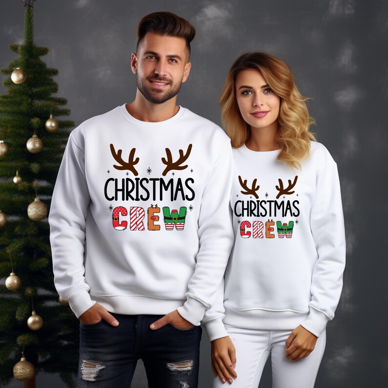 cute christmas crew sweatshirt with reindeer antlers and personalized sleeve name option, matching holiday family sweater for kids and adults, custom christmas shirt for winter celebrations, cozy xmas crew top with festive lettering, personalized holiday gift sweatshirt, christmas pajamas top for family photos, fun reindeer themed christmas sweater, holiday party outfit idea, custom name christmas crew shirt, adorable winter sweatshirt for holiday season