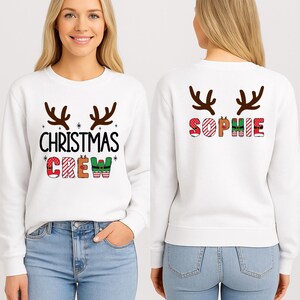 cute christmas crew sweatshirt with reindeer antlers and personalized sleeve name option, matching holiday family sweater for kids and adults, custom christmas shirt for winter celebrations, cozy xmas crew top with festive lettering, personalized holiday gift sweatshirt, christmas pajamas top for family photos, fun reindeer themed christmas sweater, holiday party outfit idea, custom name christmas crew shirt, adorable winter sweatshirt for holiday season