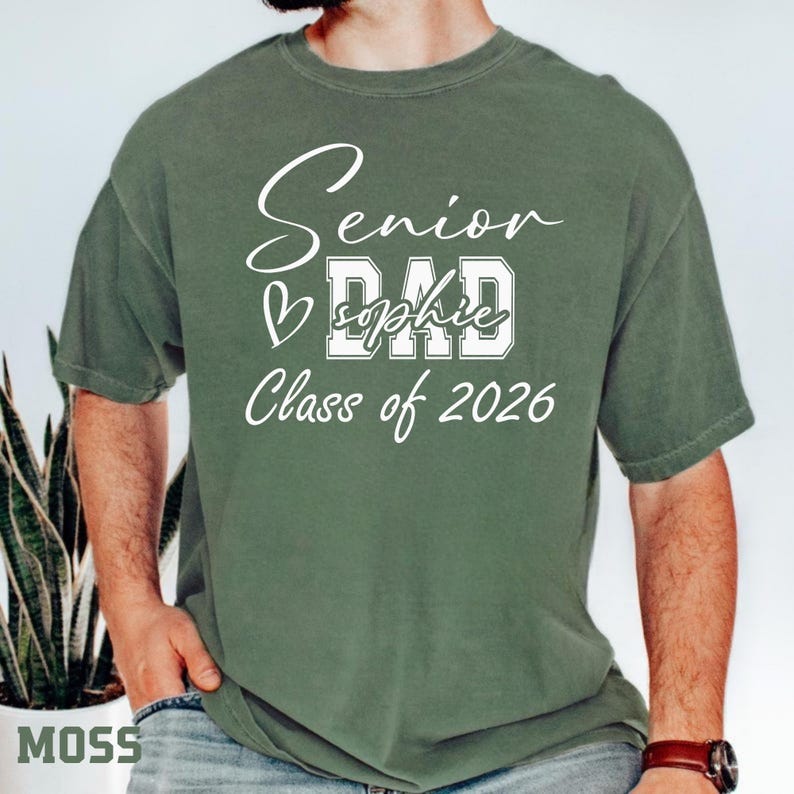 Comfort Colors® blue jean senior mom tee with white Class of 2026 artwork, heart detail and personalized name design. This soft casual graduation shirt is made for moms who want a meaningful senior year keepsake. Wear it to graduation ceremonies, senior events, school spirit days, family parties, photo sessions and Class of 2026 celebrations.