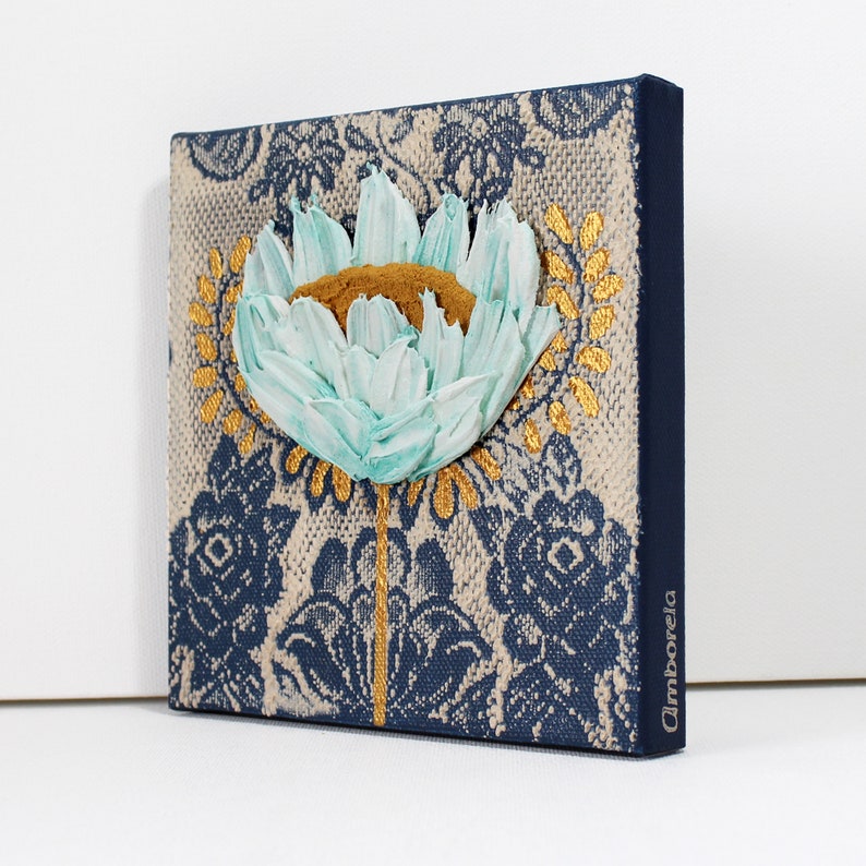 Side view of miniature painting in art deco style with a blue impasto flower on a textured background with golden leaves
