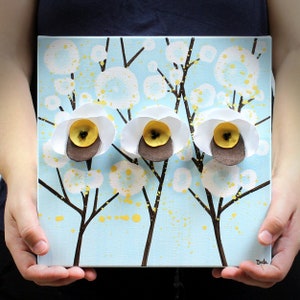 Held in hand for scale view of cheerful painting gift for mom with 3d flowers on a small canvas art in blue, yellow, and white