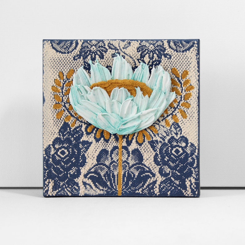 Front view of miniature painting in art deco style with a blue impasto flower on a textured background with golden leaves